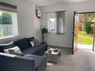 a living room with a blue couch and a table at Villa Hebane in El Puerto de Santa María