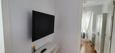 a bathroom with a television on a white wall at Cobos by Gades Gestión in Cádiz