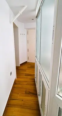 a hallway of an apartment with wood floors and a window at Cobos by Gades Gestión in Cádiz
