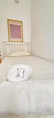a white bed with a white blanket on it at Cobos by Gades Gestión in Cádiz