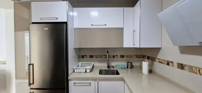 a kitchen with white cabinets and a stainless steel refrigerator at Cobos by Gades Gestión in Cádiz