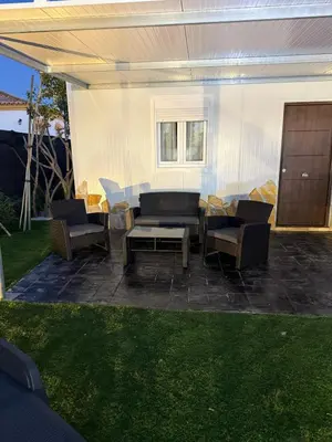 a patio with chairs and a couch and a table at casitas de las palmeras in Cádiz