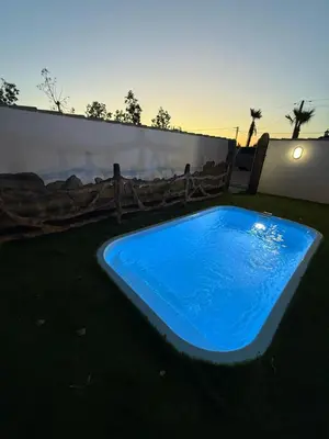 a large blue swimming pool in a yard at casitas de las palmeras in Cádiz