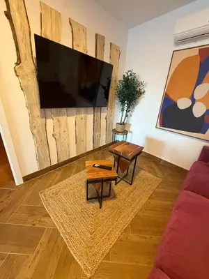 a living room with a couch and a flat screen tv at casitas de las palmeras in Cádiz