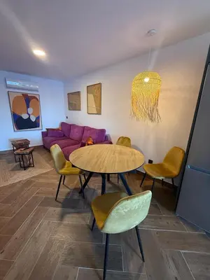 a living room with a table and a purple couch at casitas de las palmeras in Cádiz