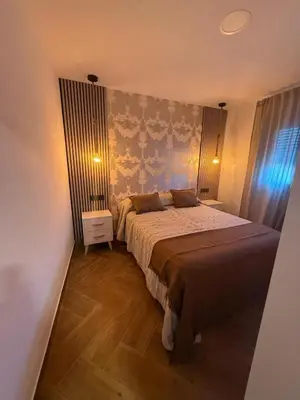 a bedroom with a large bed in a room at casitas de las palmeras in Cádiz