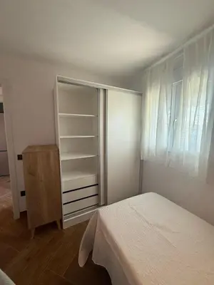 a bedroom with a bed and a dresser and a closet at casitas de las palmeras in Cádiz
