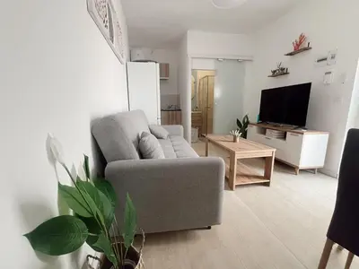 a living room with a couch and a tv at Apartamento patio Andaluz in Rota
