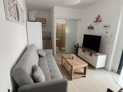 a living room with a couch and a tv at Apartamento patio Andaluz in Rota