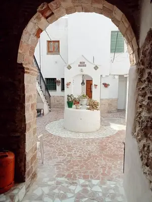 an entrance to a building with an archway with potted plants at Apartamento patio Andaluz in Rota