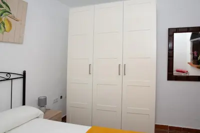 a bedroom with white cabinets and a bed and a mirror at Casa Rural con Jacuzzi en Conil de la Frontera in Cádiz