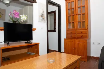 a living room with a television on a wooden table at Casa Rural con Jacuzzi en Conil de la Frontera in Cádiz