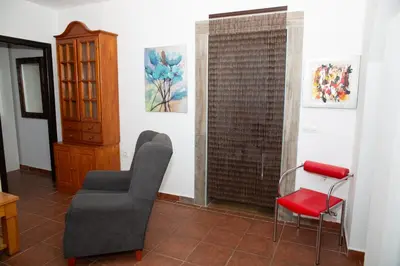 a living room with a chair and a table at Casa Rural con Jacuzzi en Conil de la Frontera in Cádiz