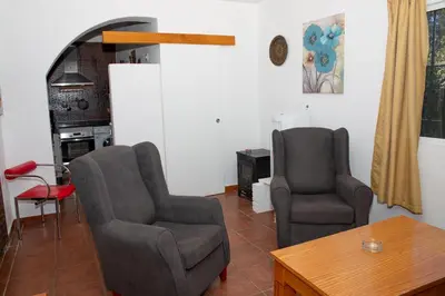 a living room with two chairs and a television at Casa Rural con Jacuzzi en Conil de la Frontera in Cádiz