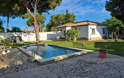 a swimming pool in a yard with a house at Villa Clara Chiclana in Chiclana de la Frontera