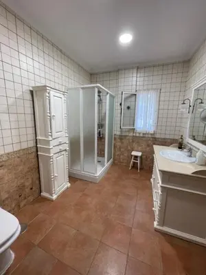 a bathroom with two sinks and a shower and a toilet at Villa Clara Chiclana in Chiclana de la Frontera
