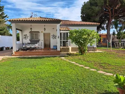 a small white house with a porch and a yard at Villa Clara Chiclana in Chiclana de la Frontera