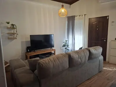 a living room with a couch and a flat screen tv at La Casita de las Piletas in Sanlúcar de Barrameda