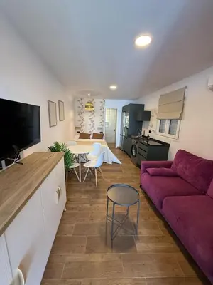 a living room with a purple couch and a table at Casita Las Palmeras 3 in Cádiz