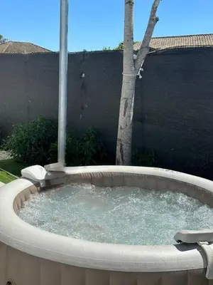 a circular hot tub in a backyard with a tree at Casita Las Palmeras 3 in Cádiz