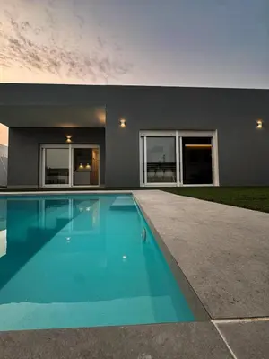 a swimming pool in front of a house at Villas tesoro del pirata in Conil de la Frontera