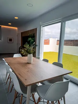 a dining room with a wooden table and chairs at Villas tesoro del pirata in Conil de la Frontera