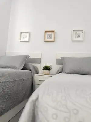 two beds sitting next to each other in a bedroom at Villas tesoro del pirata in Conil de la Frontera