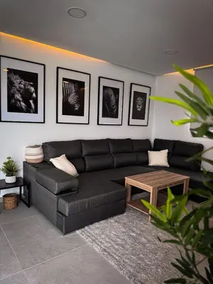a living room with a black couch and a table at Villas tesoro del pirata in Conil de la Frontera