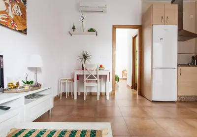 a kitchen with a table and a white refrigerator at San Juan Apartamento in Jerez de la Frontera