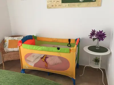 a toy crib in a room with a table at San Juan Apartamento in Jerez de la Frontera