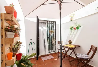 a patio with a table and chairs and an umbrella at San Juan Apartamento in Jerez de la Frontera