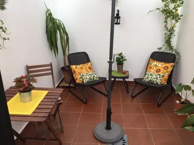 a porch with two chairs and a floor lamp at San Juan Apartamento in Jerez de la Frontera