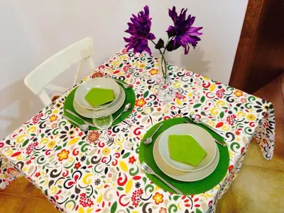 a table with two plates and a vase with flowers on it at San Juan Apartamento in Jerez de la Frontera