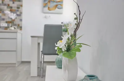 a white vase with flowers in it on a table at Casa el rincón de la Rosa in Conil de la Frontera