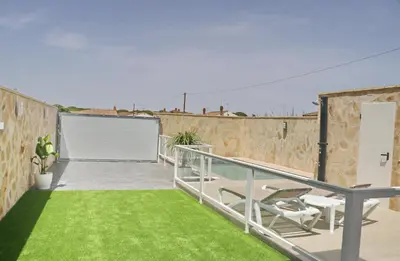 a balcony with a lawn and a white garage at Casa el rincón de la Rosa in Conil de la Frontera
