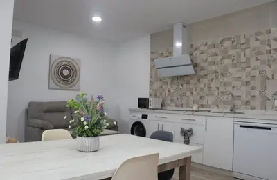 a kitchen with a table with a vase of flowers on it at Casa el rincon de la Rosa II in Conil de la Frontera