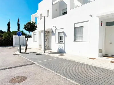 a white building with a street sign in front of it at Luz de Conil is a modern villa next to Playa Fontanilla in Conil de la Frontera