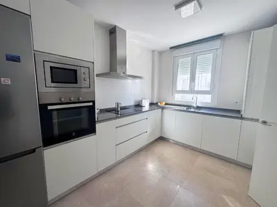 a kitchen with white cabinets and a microwave at Luz de Conil is a modern villa next to Playa Fontanilla in Conil de la Frontera