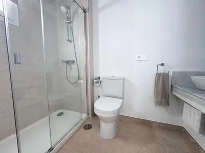 a bathroom with a shower and a toilet and a sink at Luz de Conil is a modern villa next to Playa Fontanilla in Conil de la Frontera