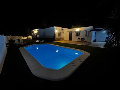 a large swimming pool in a yard at night at Azul Sancti Petri in Chiclana de la Frontera