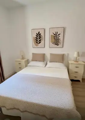 a bedroom with a white bed with two night stands at Azul Sancti Petri in Chiclana de la Frontera