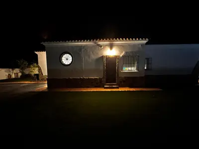 a clock on the side of a building at night at Azul Sancti Petri in Chiclana de la Frontera