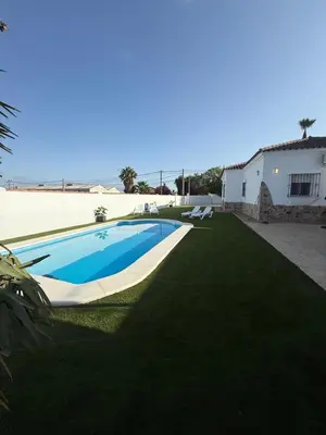 a swimming pool in a yard next to a house at Azul Sancti Petri in Chiclana de la Frontera