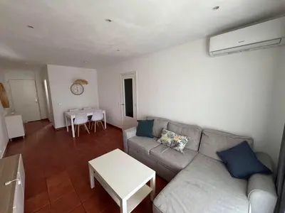 a living room with a couch and a table at Apartmento en La Barrosa con piscina in Novo Sancti Petri