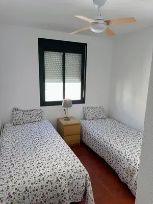 a bedroom with two beds and a ceiling fan at Apartmento en La Barrosa con piscina in Novo Sancti Petri