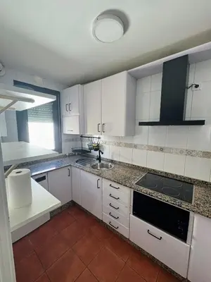 a kitchen with white cabinets and a sink at Apartmento en La Barrosa con piscina in Novo Sancti Petri