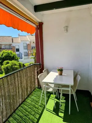 a white table and chairs on a balcony at Apartmento en La Barrosa con piscina in Novo Sancti Petri