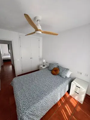 a bedroom with a bed and a ceiling fan at Apartmento en La Barrosa con piscina in Novo Sancti Petri
