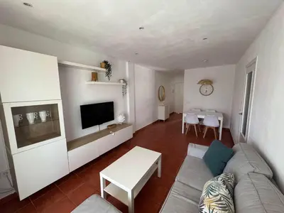 a living room with a couch and a table at Apartmento en La Barrosa con piscina in Novo Sancti Petri