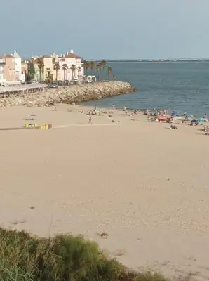 a group of people on a beach near the water at Apartamento Dali in El Puerto de Santa María